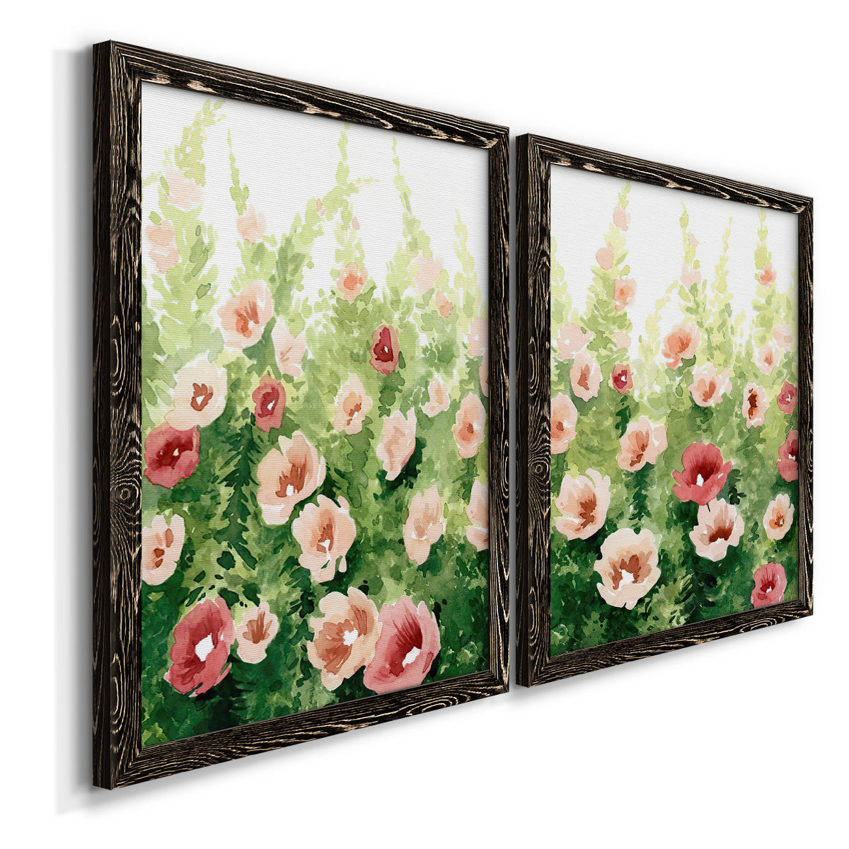 Angled view of a set of two black barnwood framed canvas prints featuring two luminous impressionistic floral paintings featuring a field of pink coral and white flowers.