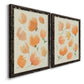 Angled view of a set of two black barnwood framed canvas prints featuring two airy watercolor floral paintings featuring loose peach-orange tulip-like blossoms.