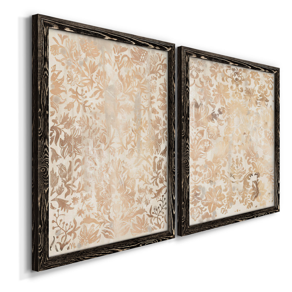 Angled view of a set of two black barnwood framed canvas prints featuring two vintage decorative prints featuring ornate cream floral damask patterns.