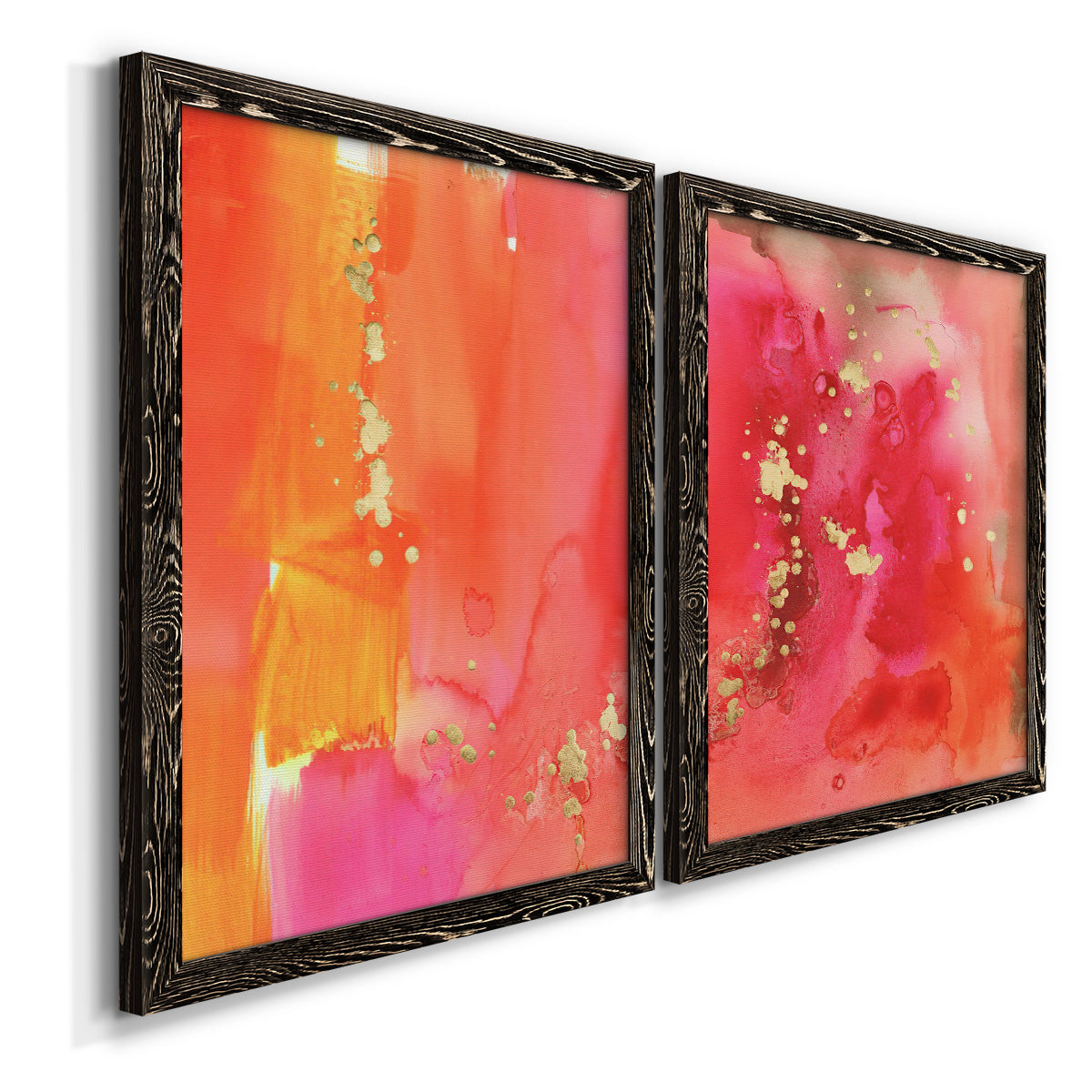 Angled view of a set of two black barnwood framed canvas prints featuring two glamorous fluid abstracts featuring luminous coral orange and pink color fields with gold flecks.
