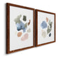 Angled view of a set of two maple barnwood framed canvas prints featuring two airy minimalist abstracts featuring scattered translucent watercolor shapes.