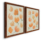 Angled view of a set of two maple barnwood framed canvas prints featuring two airy watercolor floral paintings featuring loose peach-orange tulip-like blossoms.
