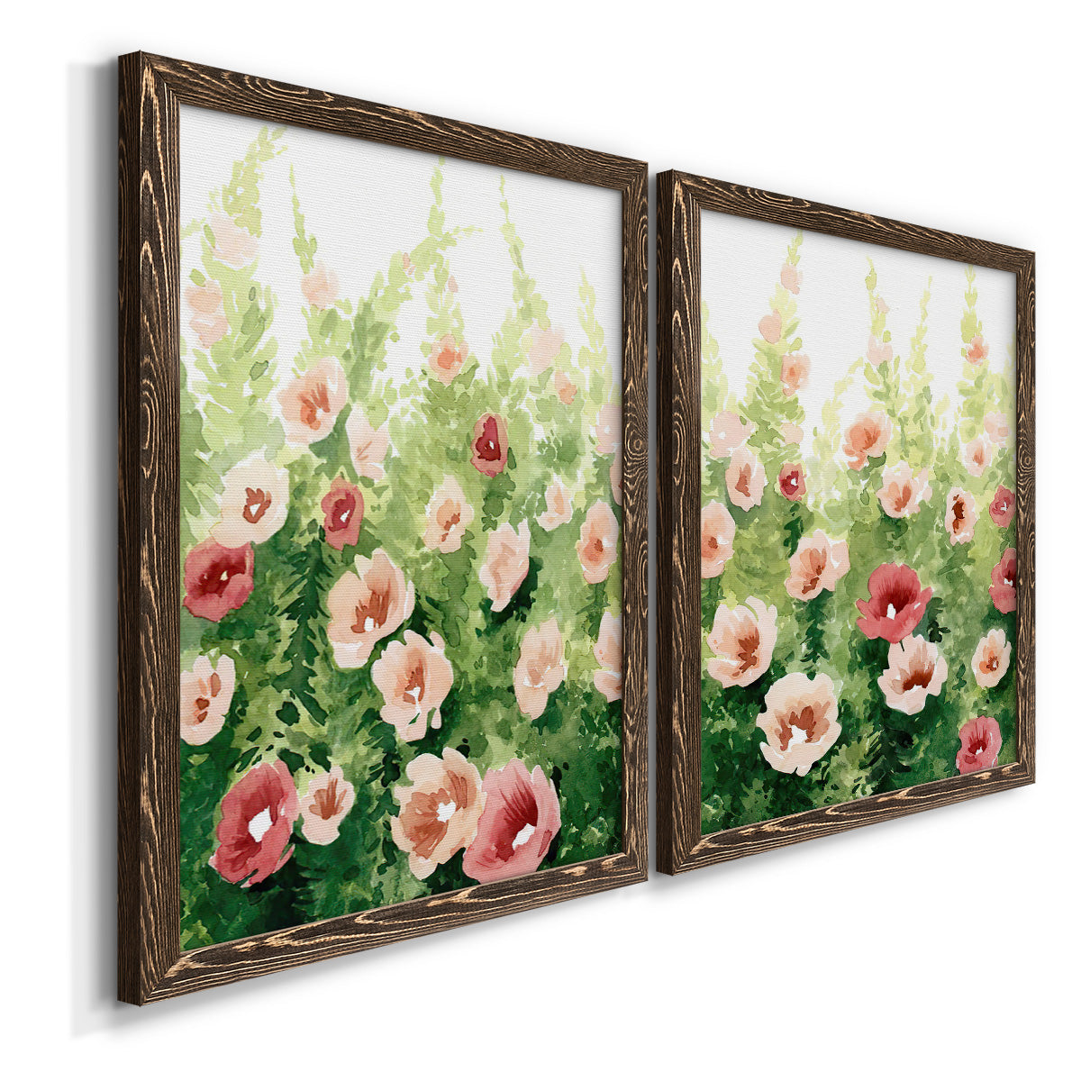 Angled view of a set of two walnut barnwood framed canvas prints featuring two luminous impressionistic floral paintings featuring a field of pink coral and white flowers.