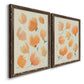 Angled view of a set of two walnut barnwood framed canvas prints featuring two airy watercolor floral paintings featuring loose peach-orange tulip-like blossoms.