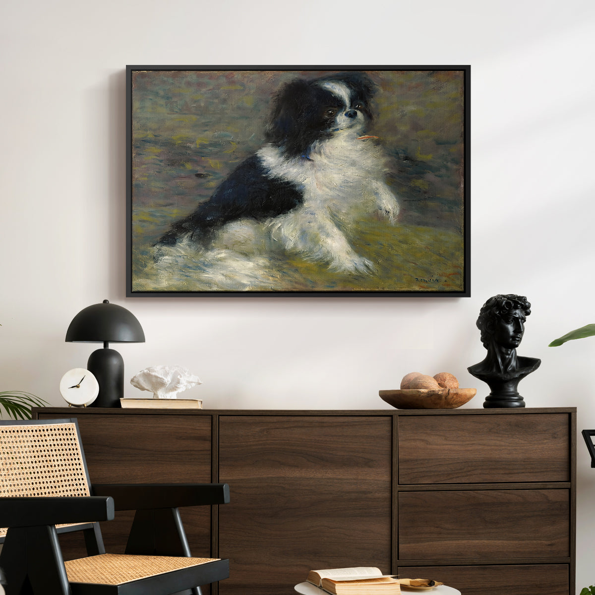 Tama, the Japanese Dog, c. 1876 by Pierre-Auguste Renoir displayed in a black floater framed canvas above a dark wood credenza in an entryway.