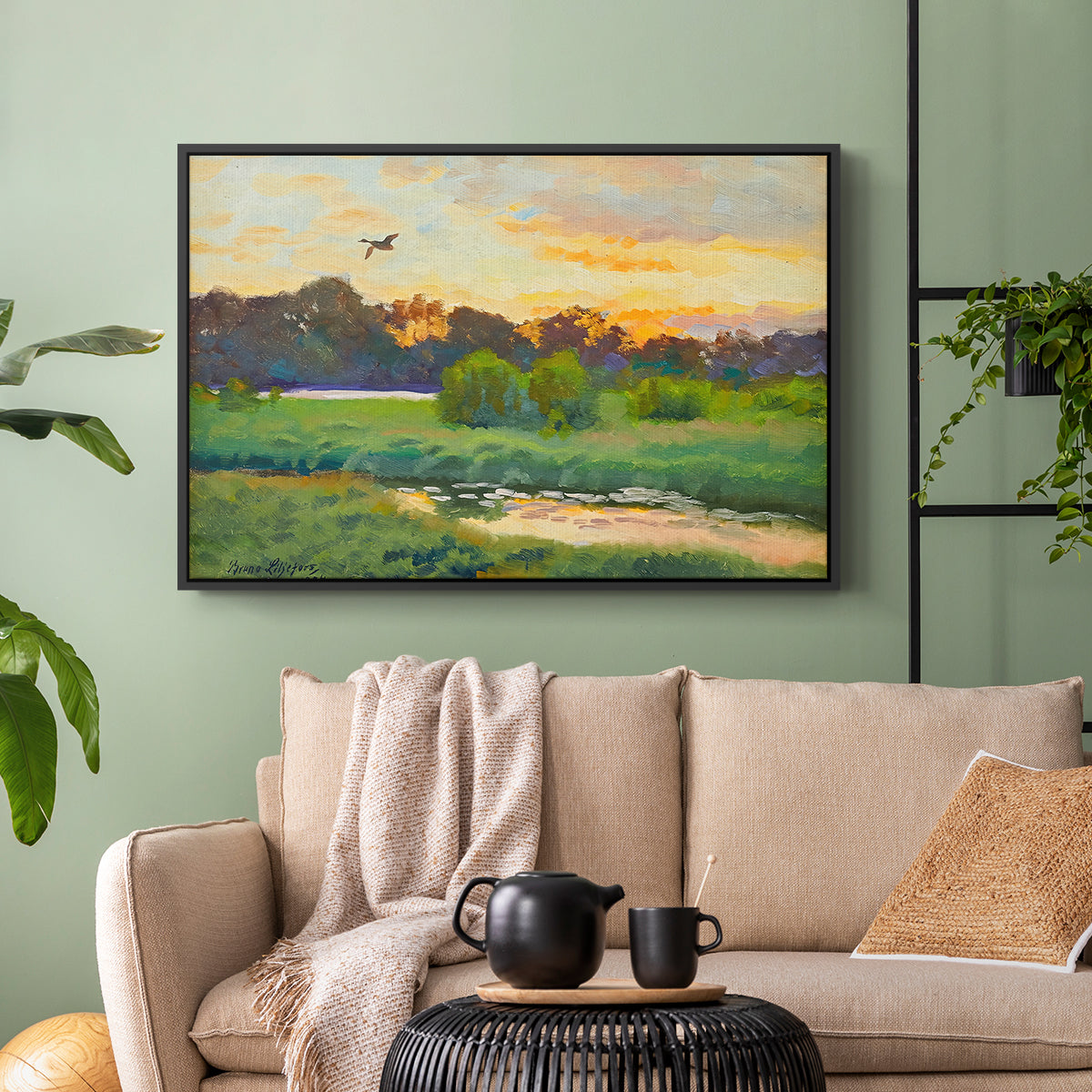 Black floater framed canvas featuring a lone duck flying over a marsh at golden hour, displayed above a sofa in a modern living room.