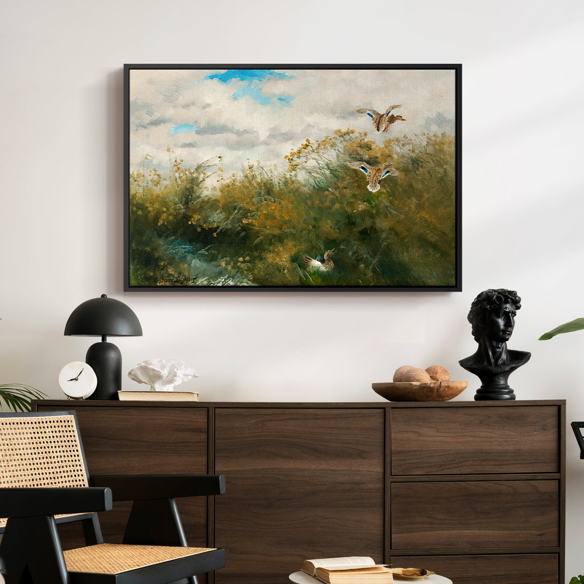 Wild Ducks (Grasänder), 1890 by Bruno Liljefors displayed in a black floater framed canvas above a dark wood credenza in an entryway.
