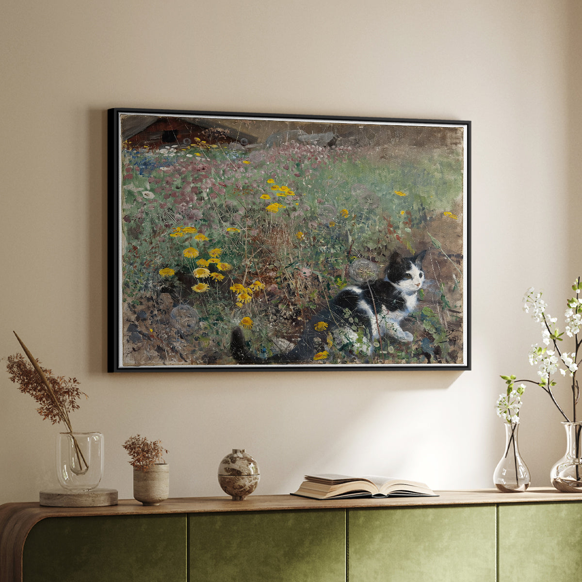 Black floater framed canvas of Cat on a Flowery Meadow, 1887 by Bruno Liljefors, featuring a small cat resting among colorful flowers in grassy field above a sideboard in a softly lit hallway.