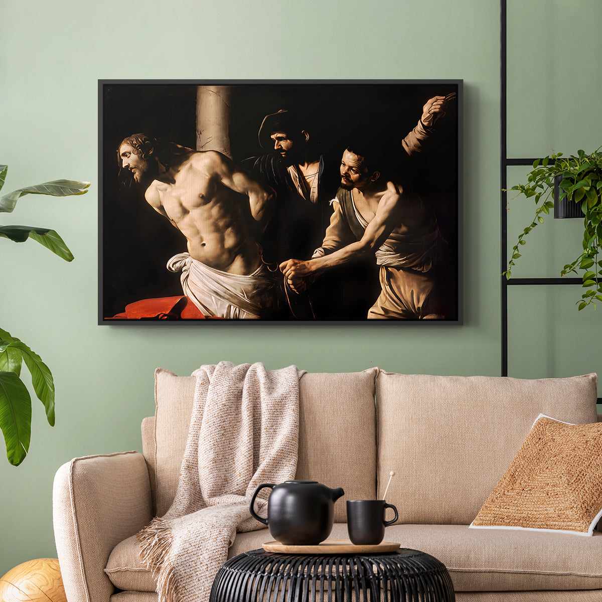 Black floater framed canvas featuring an intense Baroque scene of suffering with strong light and shadow, displayed above a sofa in a modern living room.