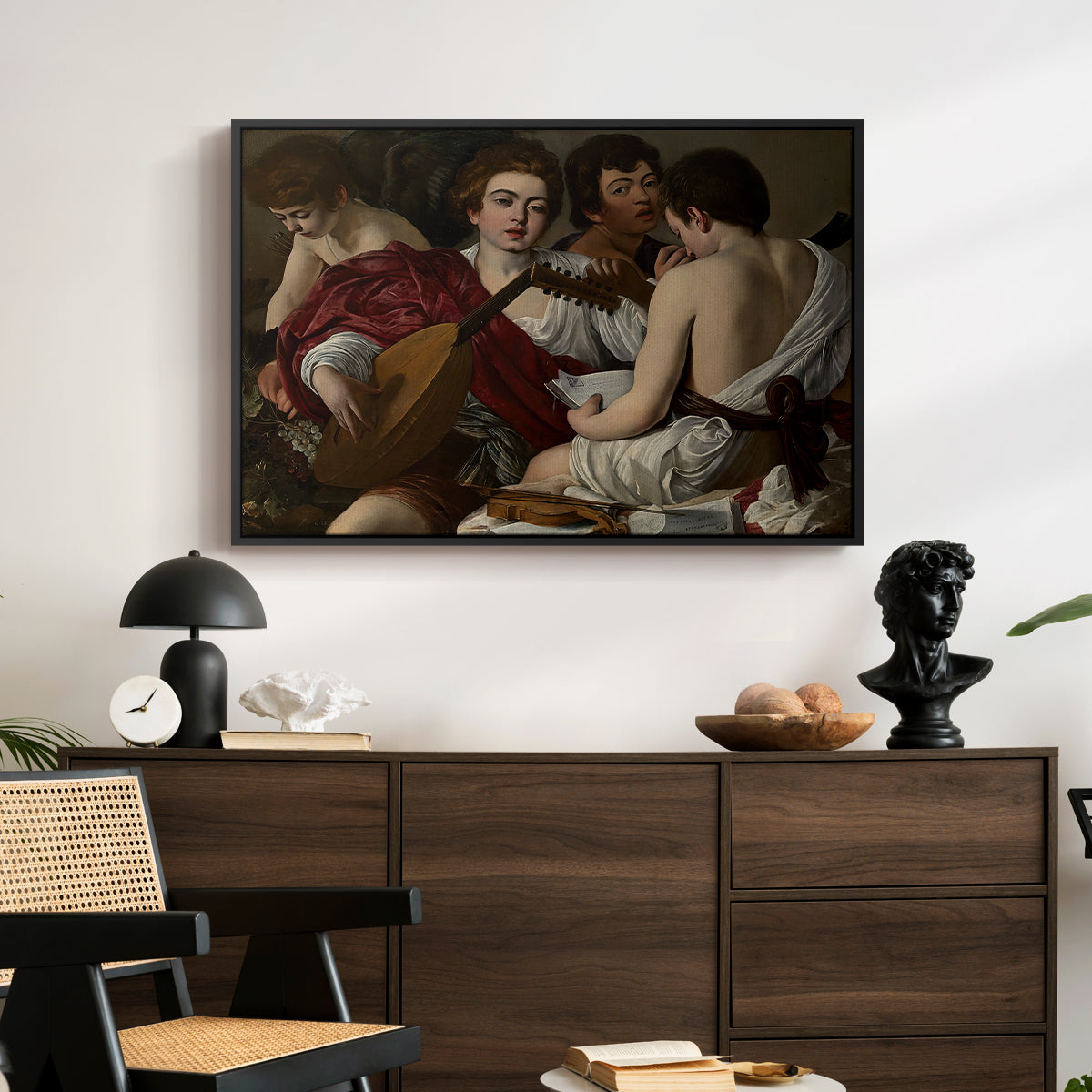 The Musicians, c. 1595 by Caravaggio displayed in a black floater framed canvas above a dark wood credenza in an entryway.