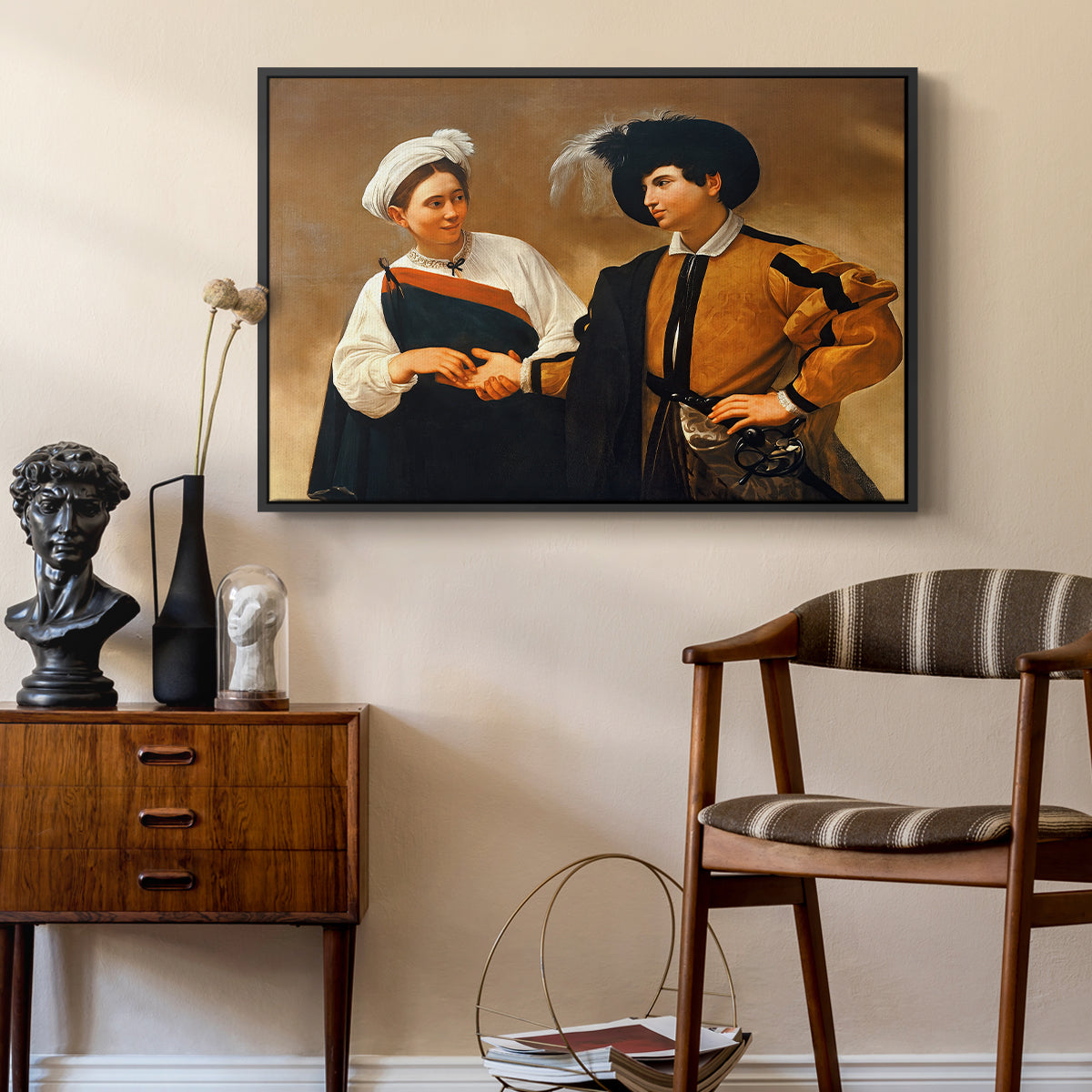 The Fortune Teller (Capitoline Version), c. 1599 by Caravaggio as a black floater framed canvas featuring a close interaction between two figures involving deception and gesture, styled above a mid-century console in a contemporary living area.