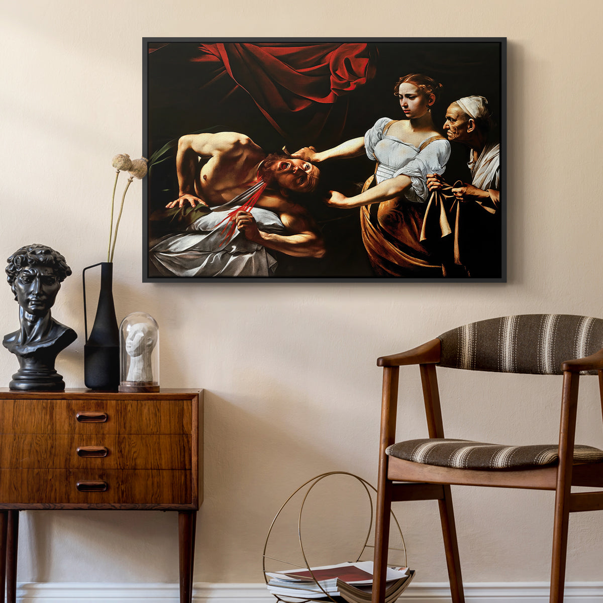 Judith Beheading Holofernes, c. 1599 by Caravaggio as a black floater framed canvas featuring an intense moment of Judith slaying Holofernes with sword, styled above a mid-century console in a contemporary living area.