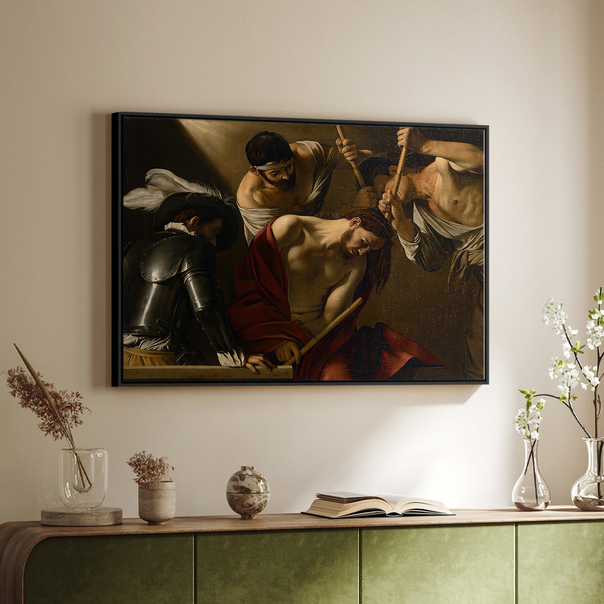 Black floater framed canvas of The Crowning with Thorns (Vienna Version), c. 1602-1604 by Caravaggio, featuring a biblical scene of Christ being mocked and crowned with thorns above a sideboard in a softly lit hallway.