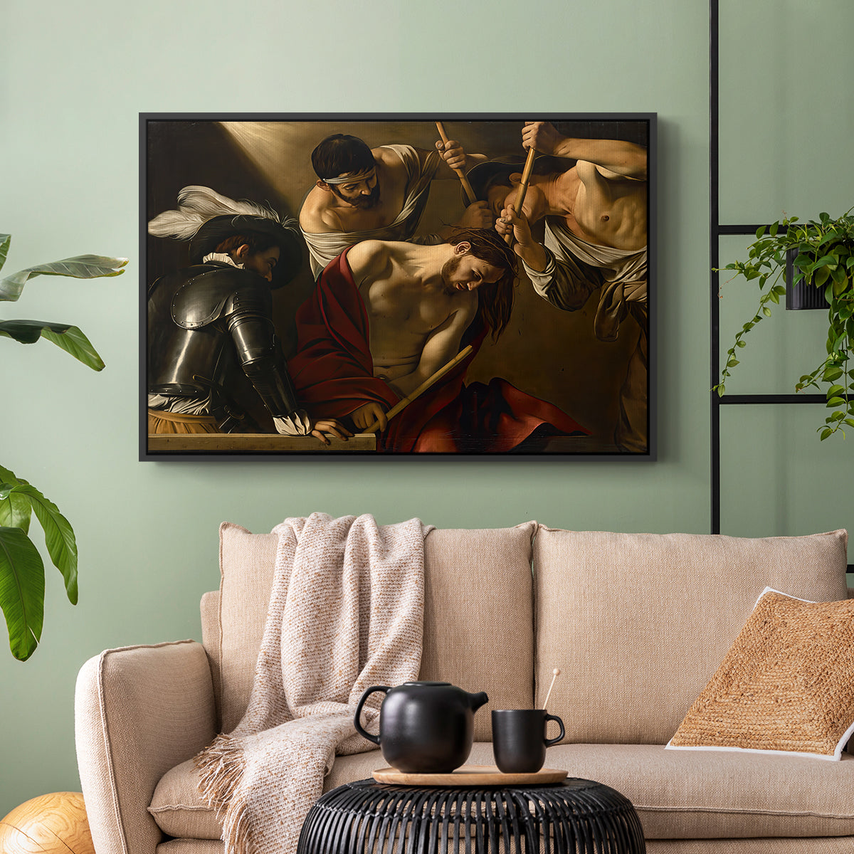 Black floater framed canvas featuring an intense religious composition with strong shadow and physical struggle, displayed above a sofa in a modern living room.