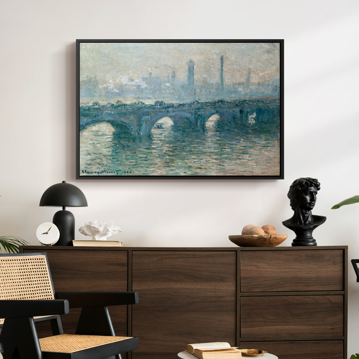 Waterloo Bridge, Gray Weather, 1900 by Claude Monet displayed in a black floater framed canvas above a dark wood credenza in an entryway.