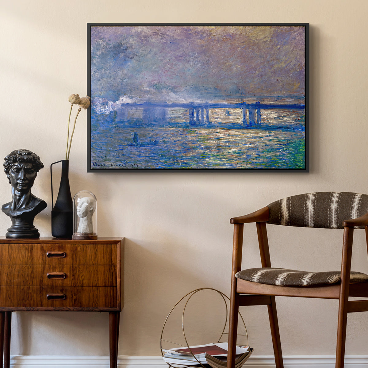 Charing Cross Bridge, 1903 by Claude Monet as a black floater framed canvas featuring an atmospheric depiction of London bridge with reflections in water, styled above a mid-century console in a contemporary living area.