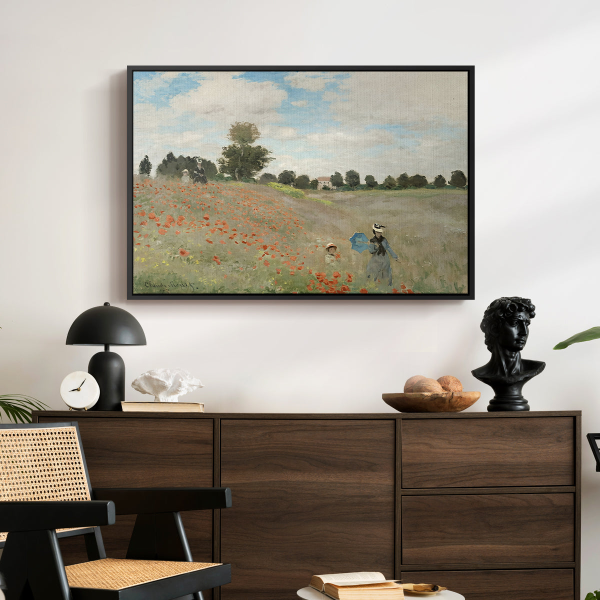 The Poppy Field near Argenteuil, 1873 by Claude Monet displayed in a black floater framed canvas above a dark wood credenza in an entryway.