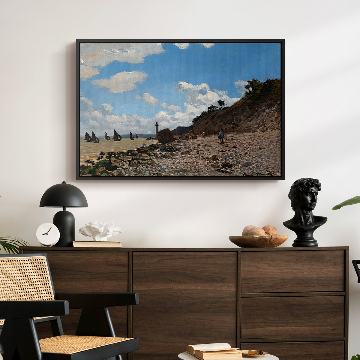 The Beach at Honfleur, 1864 by Claude Monet displayed in a black floater framed canvas above a dark wood credenza in an entryway.