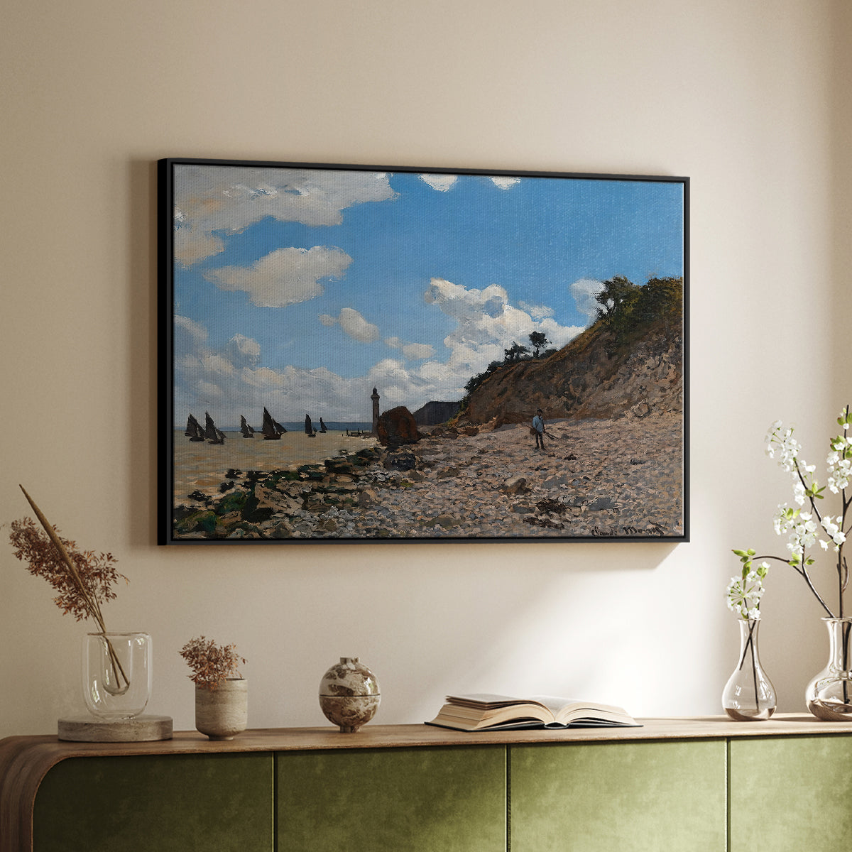 Black floater framed canvas of The Beach at Honfleur, 1864 by Claude Monet, featuring an impressionist seaside with people and sailboats under bright sky above a sideboard in a softly lit hallway.