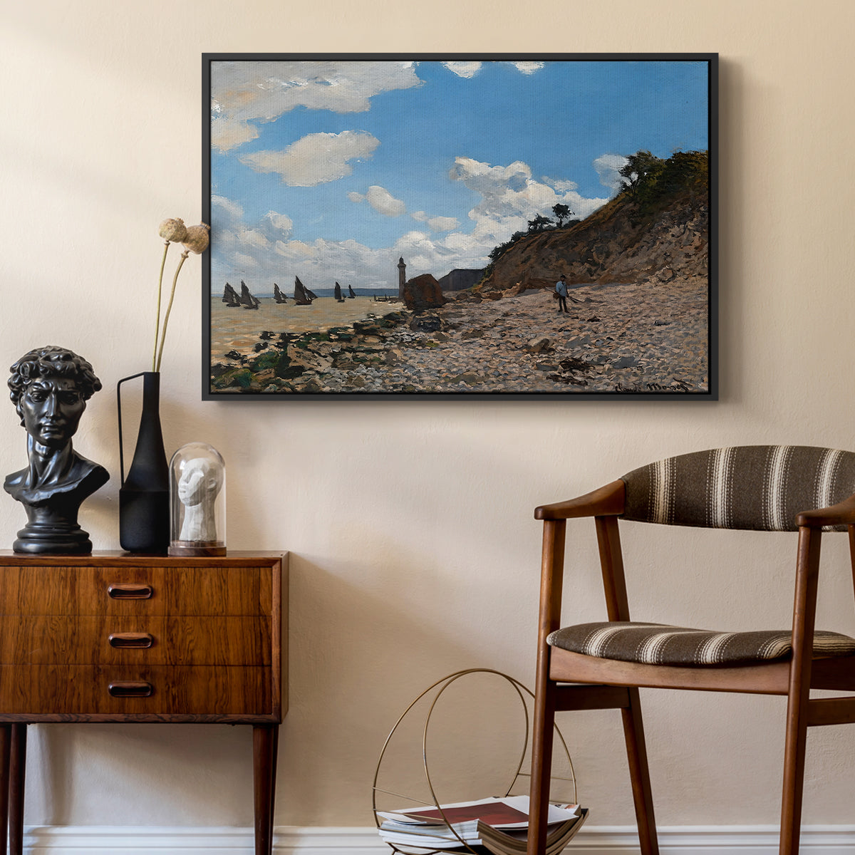 The Beach at Honfleur, 1864 by Claude Monet as a black floater framed canvas featuring a sandy beach with figures relaxing near water's edge, styled above a mid-century console in a contemporary living area.