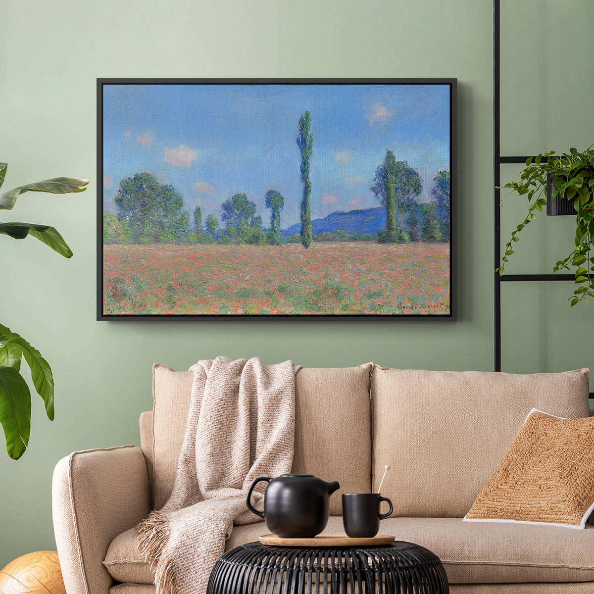 Black floater framed canvas featuring a rural field filled with red blossoms beneath open sky, displayed above a sofa in a modern living room.