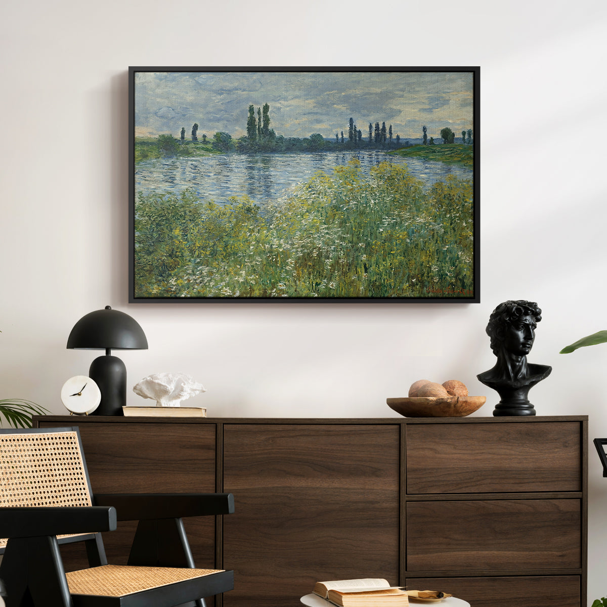 Banks of the Seine, Vétheuil, 1880 by Claude Monet displayed in a black floater framed canvas above a dark wood credenza in an entryway.