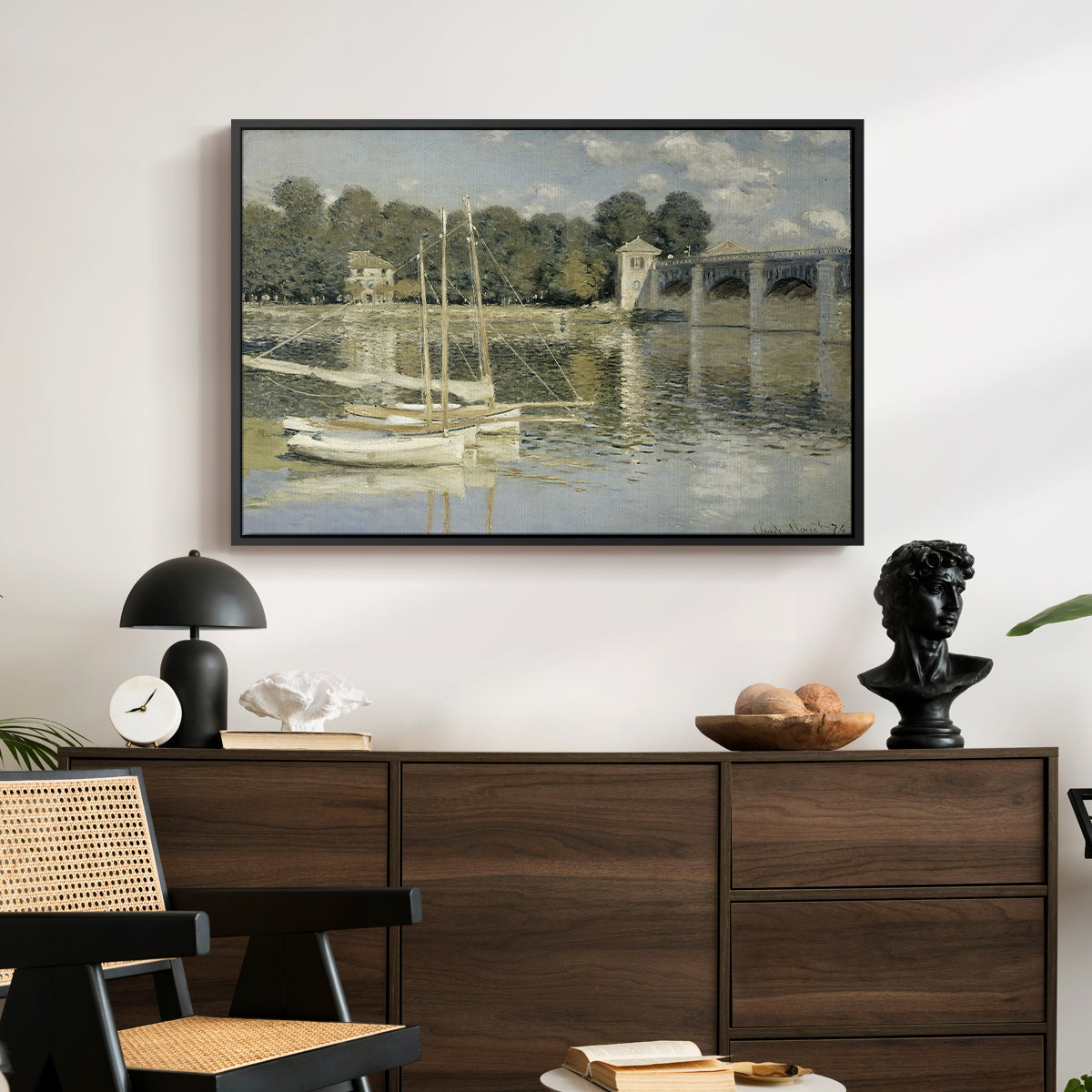 The Bridge at Argenteuil, 1874 by Claude Monet displayed in a black floater framed canvas above a dark wood credenza in an entryway.