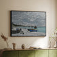 Black floater framed canvas of The Beach at Sainte-Adresse, 1867 by Claude Monet, featuring a lively beach scene with people overlooking water and ships above a sideboard in a softly lit hallway.