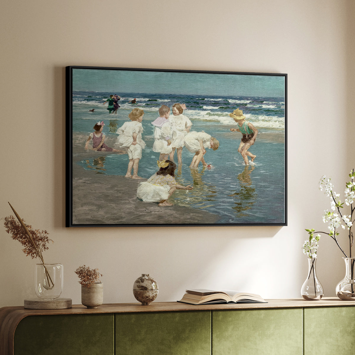 Black floater framed canvas of A Holiday, c. 1915 by Edward Henry Potthast, featuring a beach scene with figures bathing and standing in waves under bright sky above a sideboard in a softly lit hallway.