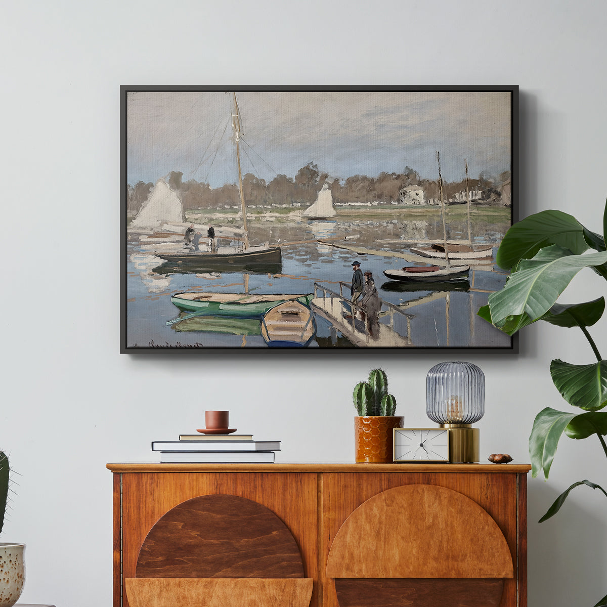 The Basin at Argenteuil, 1874 by Claude Monet in a black floater framed canvas featuring sailboats gathered in calm basin with reflections on water, displayed above a wood console cabinet.