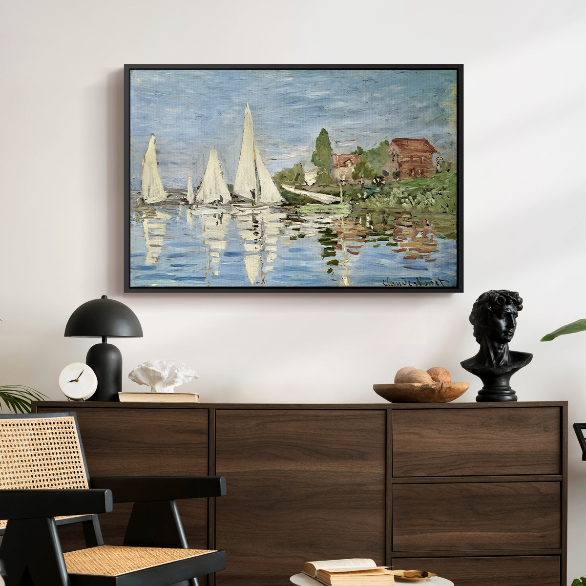 Regatta at Argenteuil, 1872 by Claude Monet displayed in a black floater framed canvas above a dark wood credenza in an entryway.