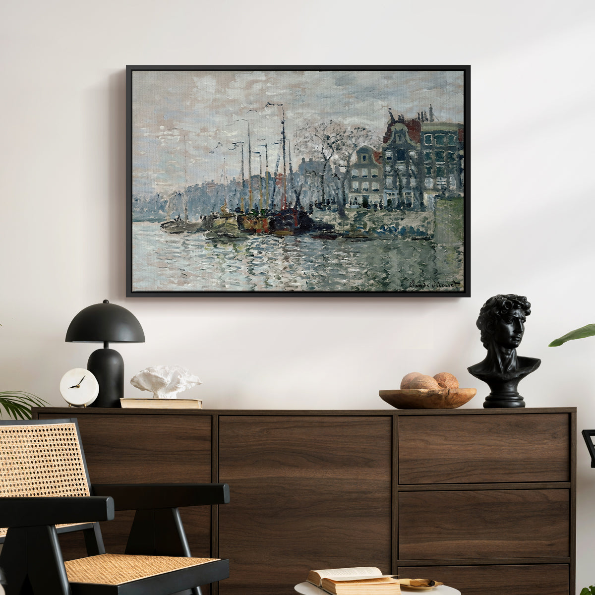 View of the Prins Hendrikkade and Kromme Waal in Amsterdam, 1874 by Claude Monet displayed in a black floater framed canvas above a dark wood credenza in an entryway.