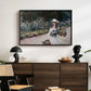 Young Girl in the Garden at Giverny, 1888 by Claude Monet displayed in a black floater framed canvas above a dark wood credenza in an entryway.