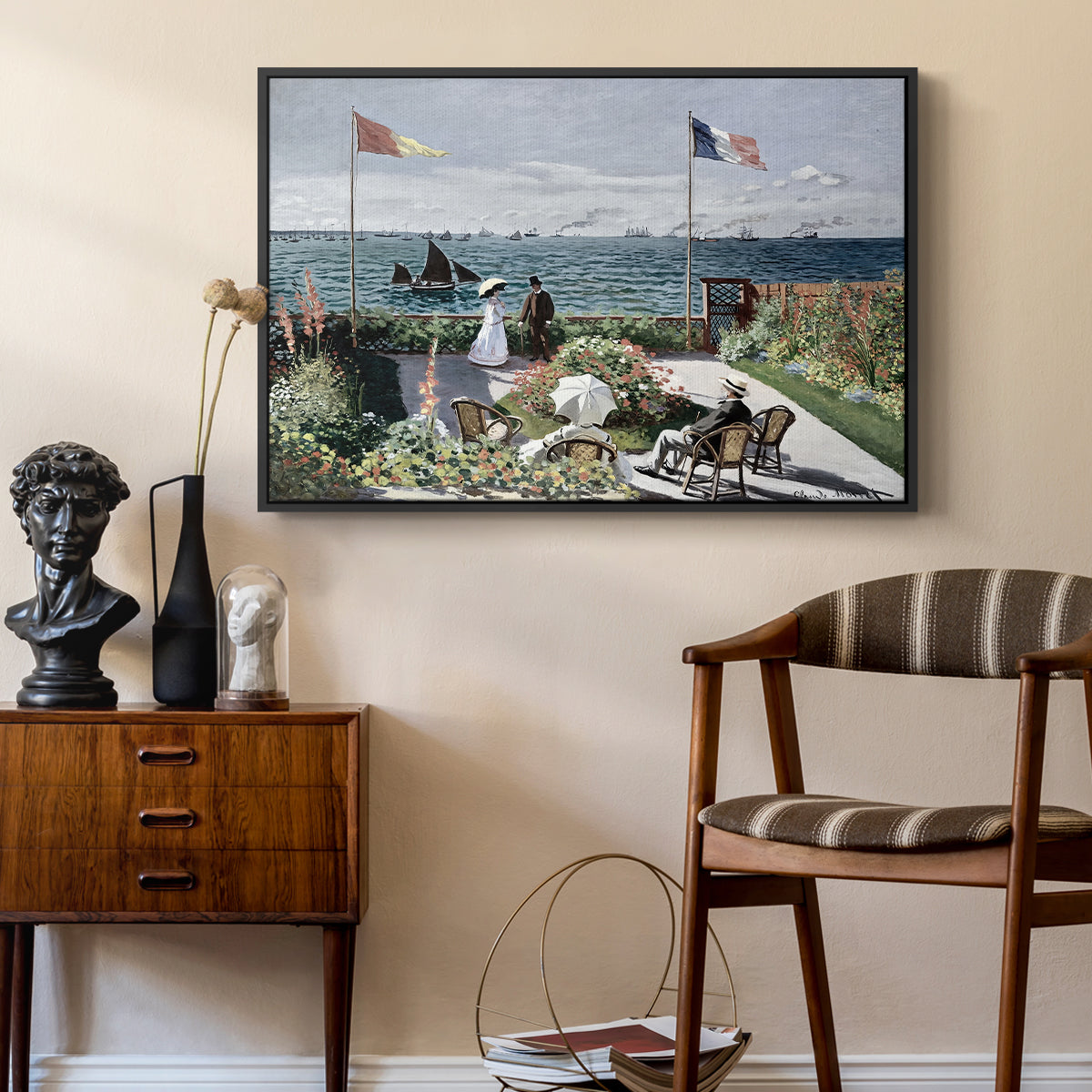 Garden at Sainte-Adresse, 1867 by Claude Monet as a black floater framed canvas featuring a vibrant garden scene with colorful blooms and distant sea, styled above a mid-century console in a contemporary living area.