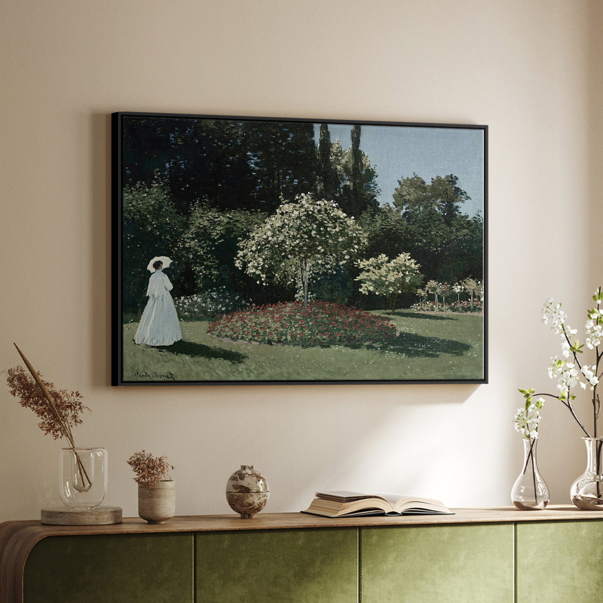 Black floater framed canvas of Woman in the Garden, Sainte-Adresse, 1867 by Claude Monet, featuring an impressionist figure in sunlit garden with lush vegetation above a sideboard in a softly lit hallway.