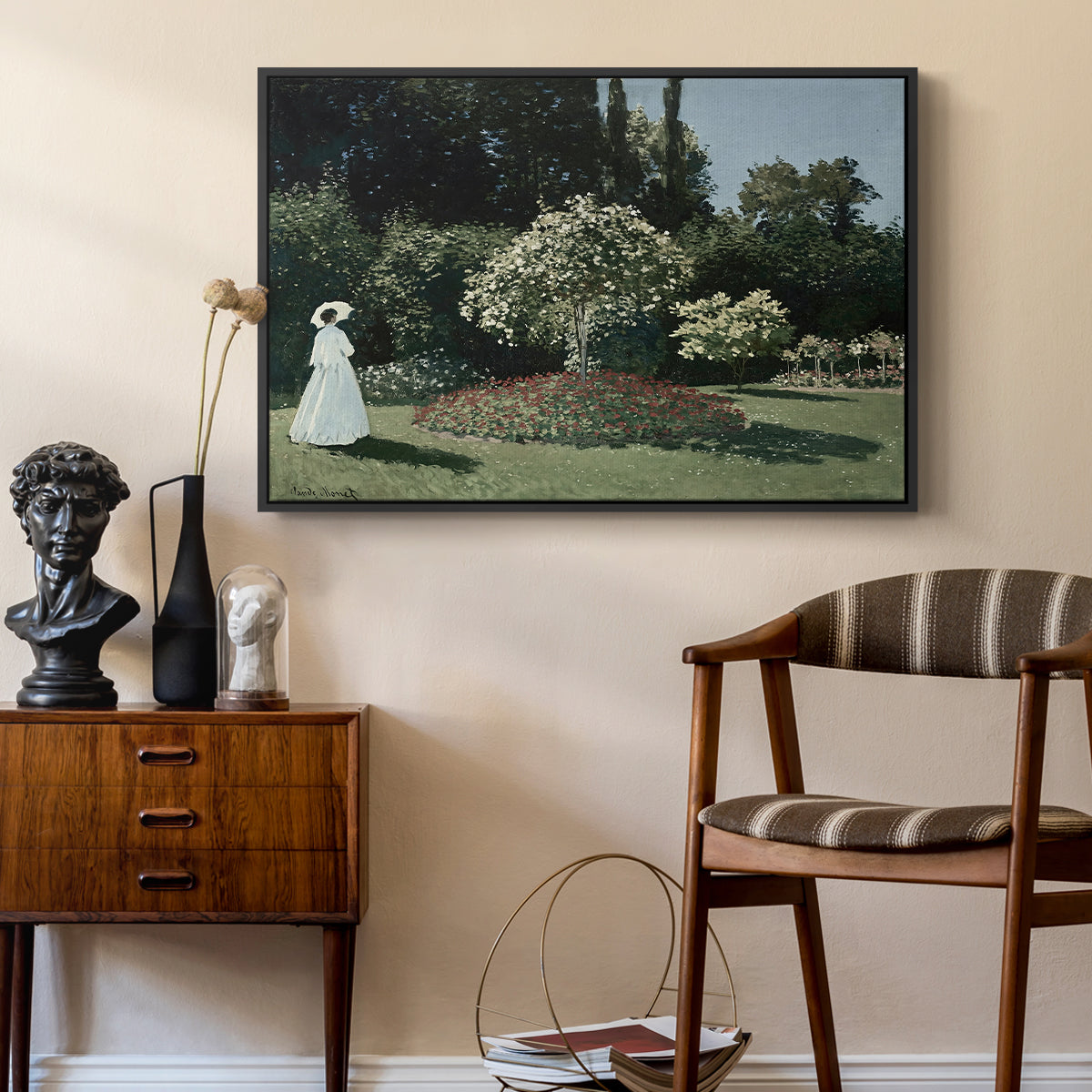 Woman in the Garden, Sainte-Adresse, 1867 by Claude Monet as a black floater framed canvas featuring an elegant woman posed outdoors among blooming plants, styled above a mid-century console in a contemporary living area.
