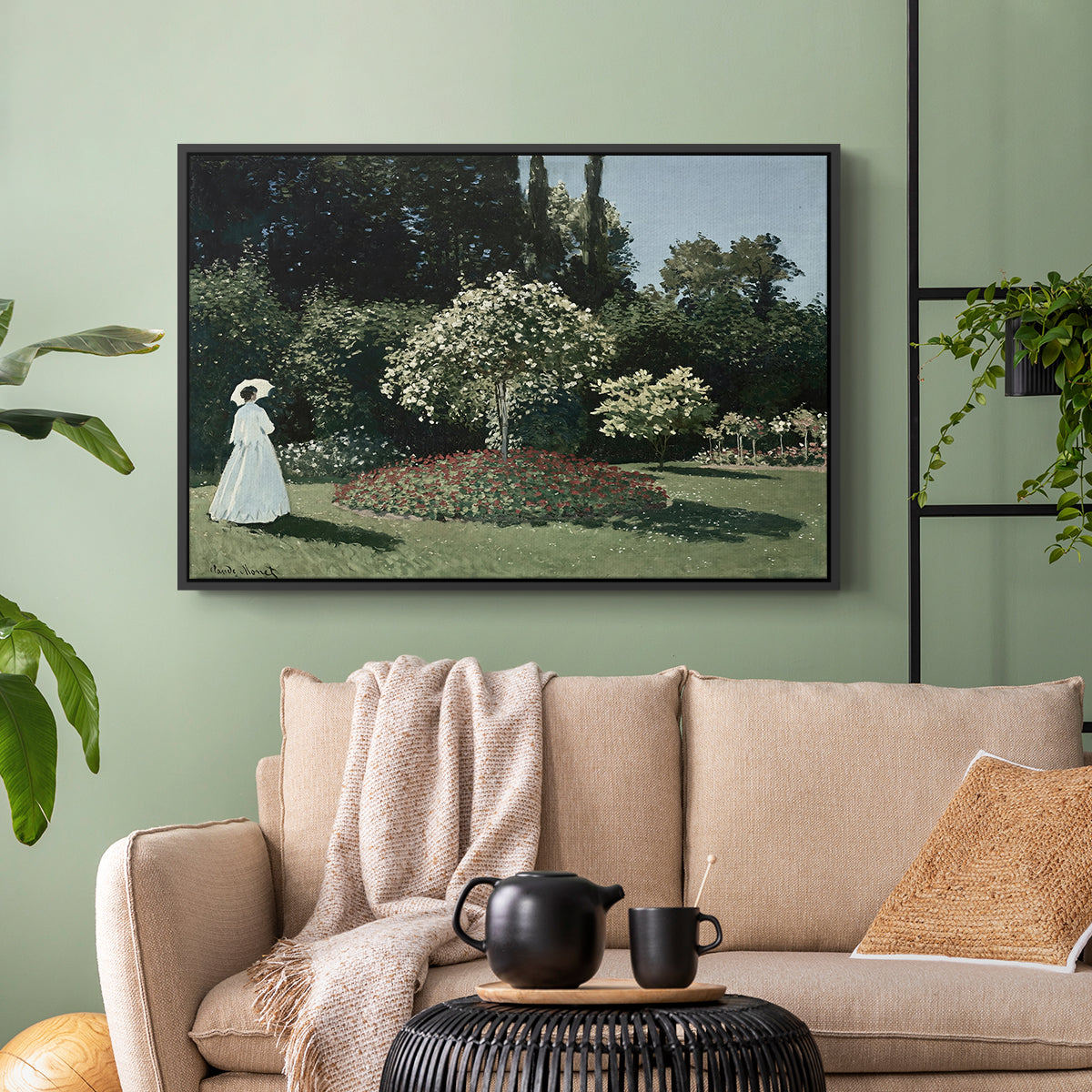 Black floater framed canvas featuring a tranquil garden portrait with soft natural light, displayed above a sofa in a modern living room.