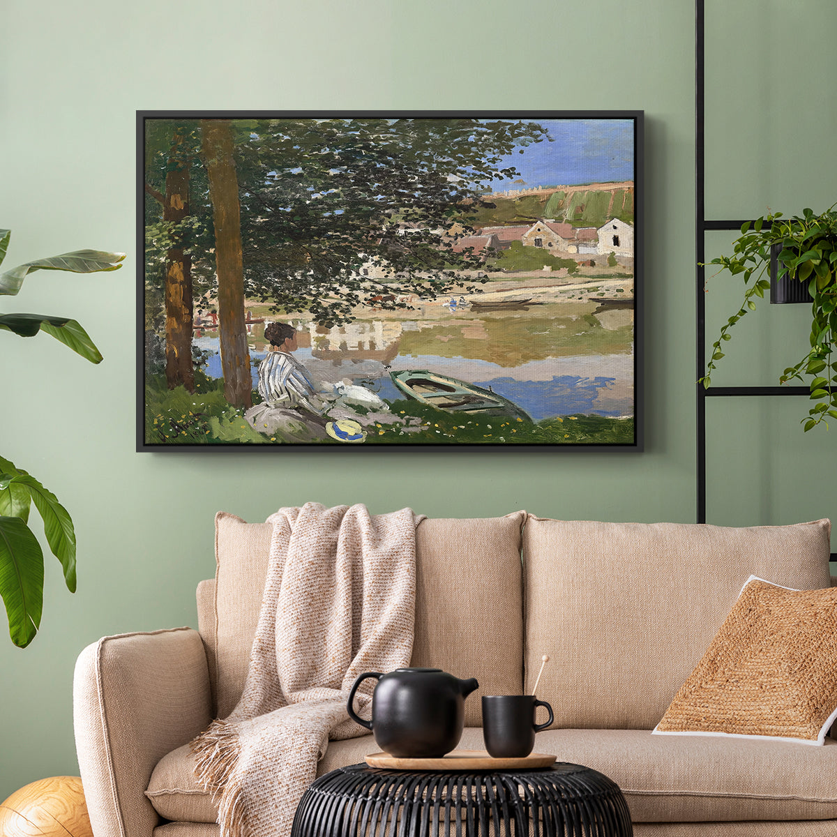 Black floater framed canvas featuring a quiet outdoor setting with figures near river under foliage, displayed above a sofa in a modern living room.