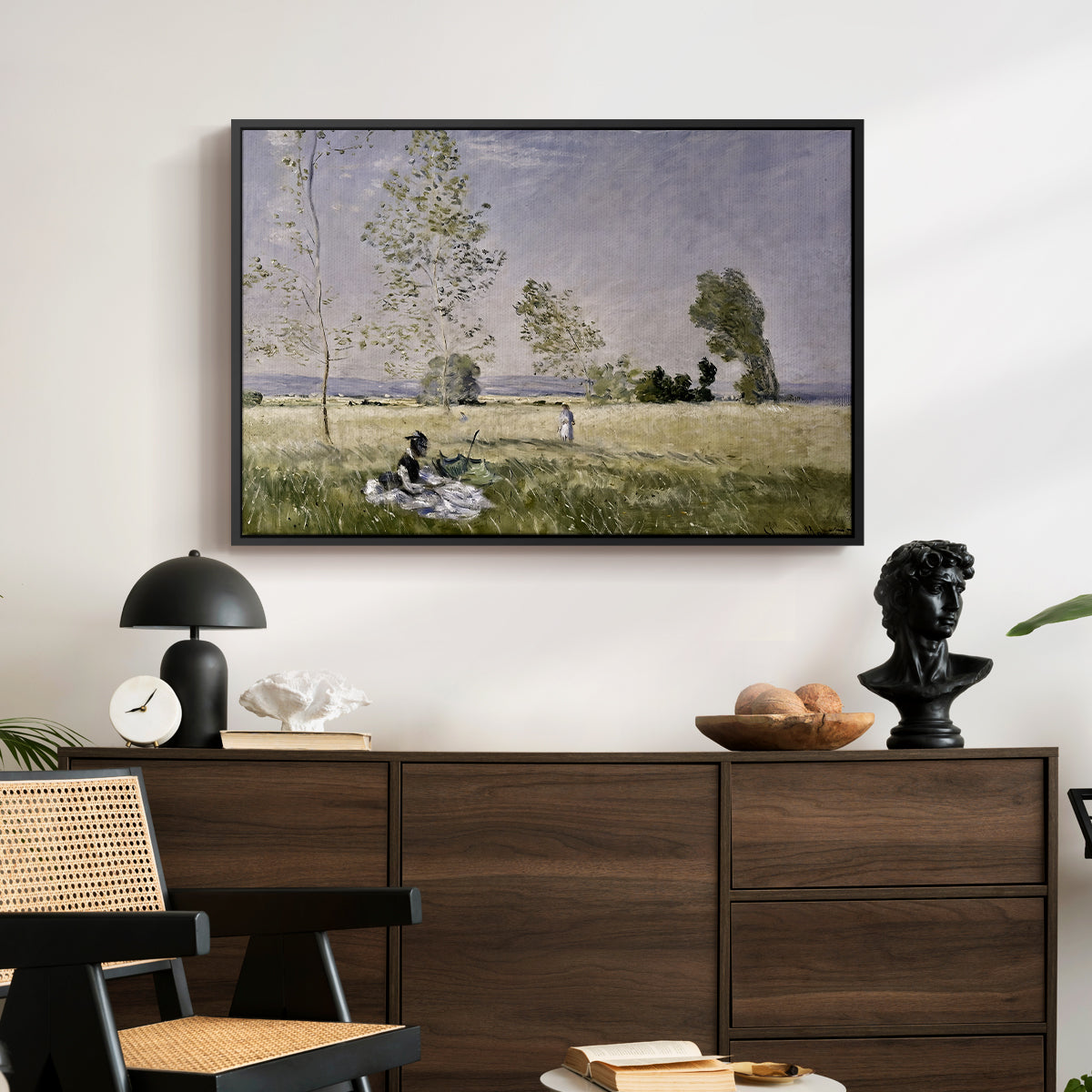 Summer (L'ete), 1874 by Claude Monet displayed in a black floater framed canvas above a dark wood credenza in an entryway.
