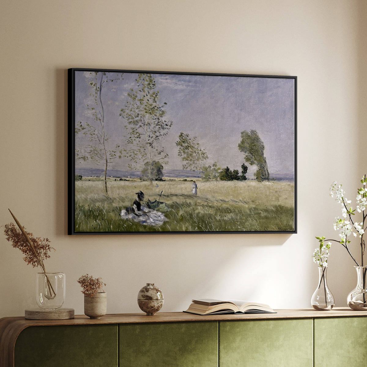 Black floater framed canvas of Summer (L'ete), 1874 by Claude Monet, featuring an impressionist countryside scene with figure resting in shade above a sideboard in a softly lit hallway.
