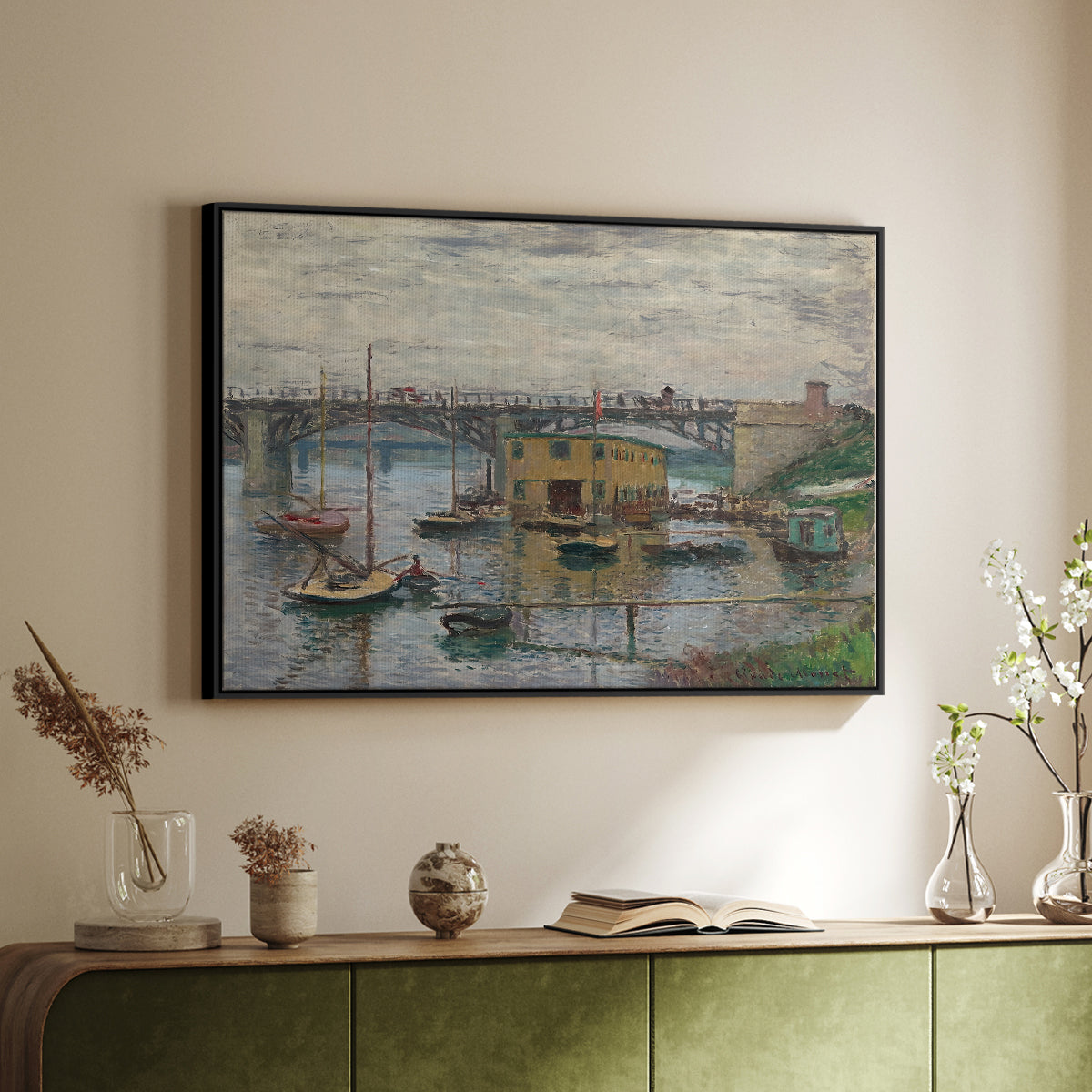 Black floater framed canvas of Bridge at Argenteuil on a Gray Day, c. 1876 by Claude Monet, featuring an impressionist riverscape with overcast atmosphere and soft tones above a sideboard in a softly lit hallway.