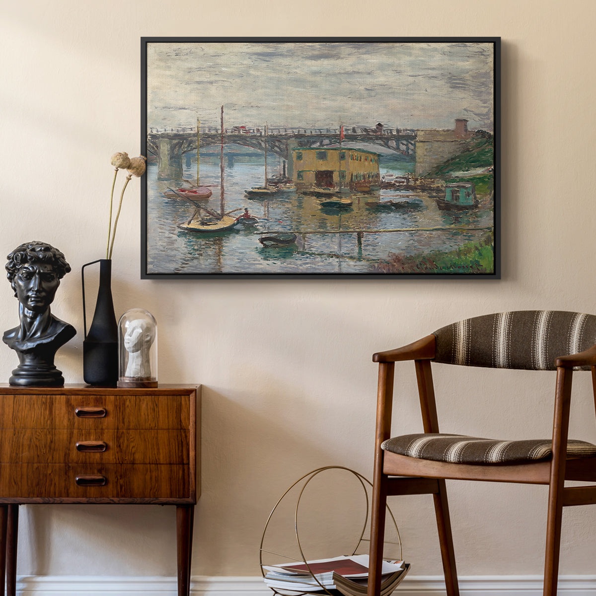 Bridge at Argenteuil on a Gray Day, c. 1876 by Claude Monet as a black floater framed canvas featuring a calm water scene with bridge fading into cloudy sky, styled above a mid-century console in a contemporary living area.