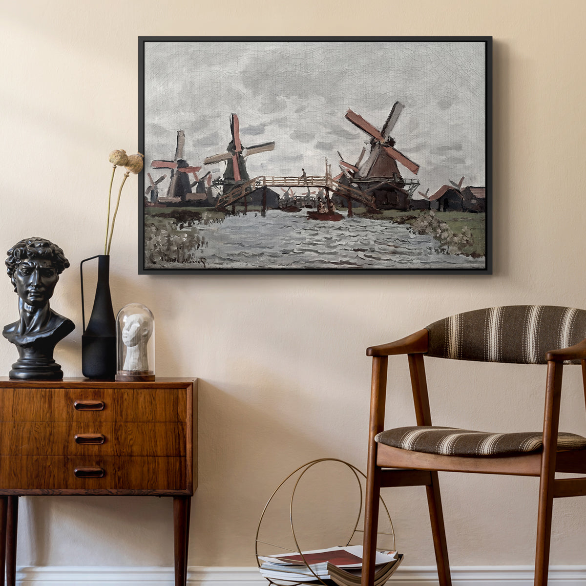 Windmills near Zaandam, 1871 by Claude Monet as a black floater framed canvas featuring a countryside scene with traditional windmills and reflections, styled above a mid-century console in a contemporary living area.