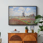 Tulip Fields with the Rijnsburg Windmill, 1886 by Claude Monet in a black floater framed canvas featuring colorful rows of tulip fields leading toward distant windmill, displayed above a wood console cabinet.