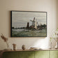 Black floater framed canvas of Windmill at Zaandam, 1871 by Claude Monet, featuring an impressionist depiction of windmill near riverbank above a sideboard in a softly lit hallway.