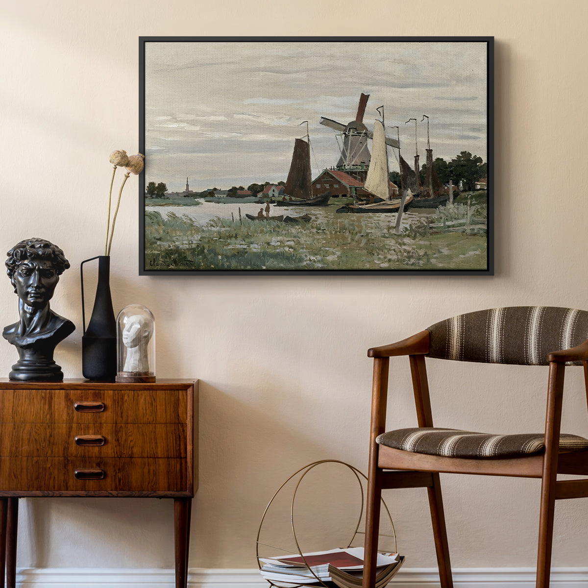 Windmill at Zaandam, 1871 by Claude Monet as a black floater framed canvas featuring a rustic scene with windmill and reflections in water, styled above a mid-century console in a contemporary living area.
