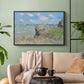 Black floater framed canvas featuring an elevated shoreline path with figures and bright sky, displayed above a sofa in a modern living room.