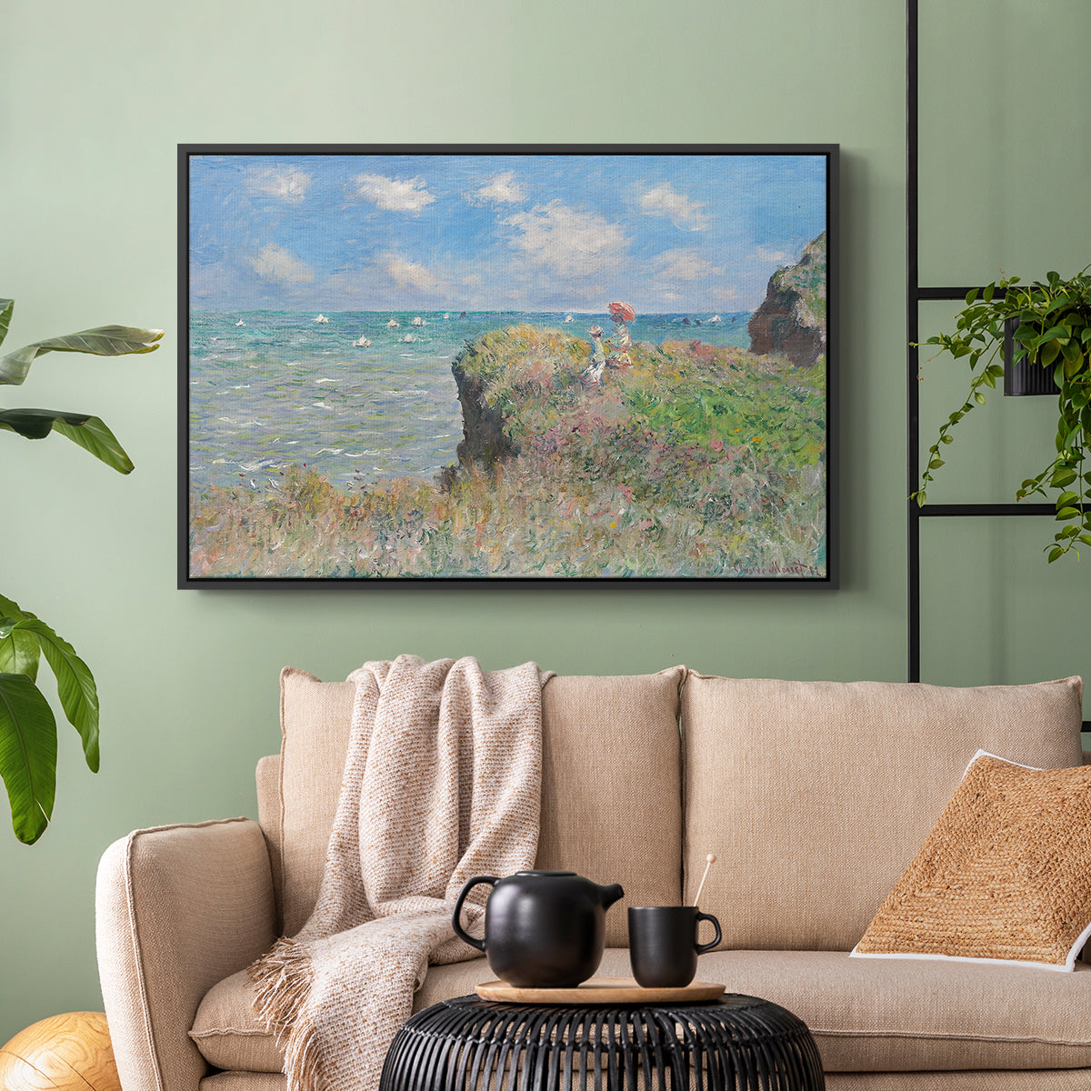 Black floater framed canvas featuring an elevated shoreline path with figures and bright sky, displayed above a sofa in a modern living room.