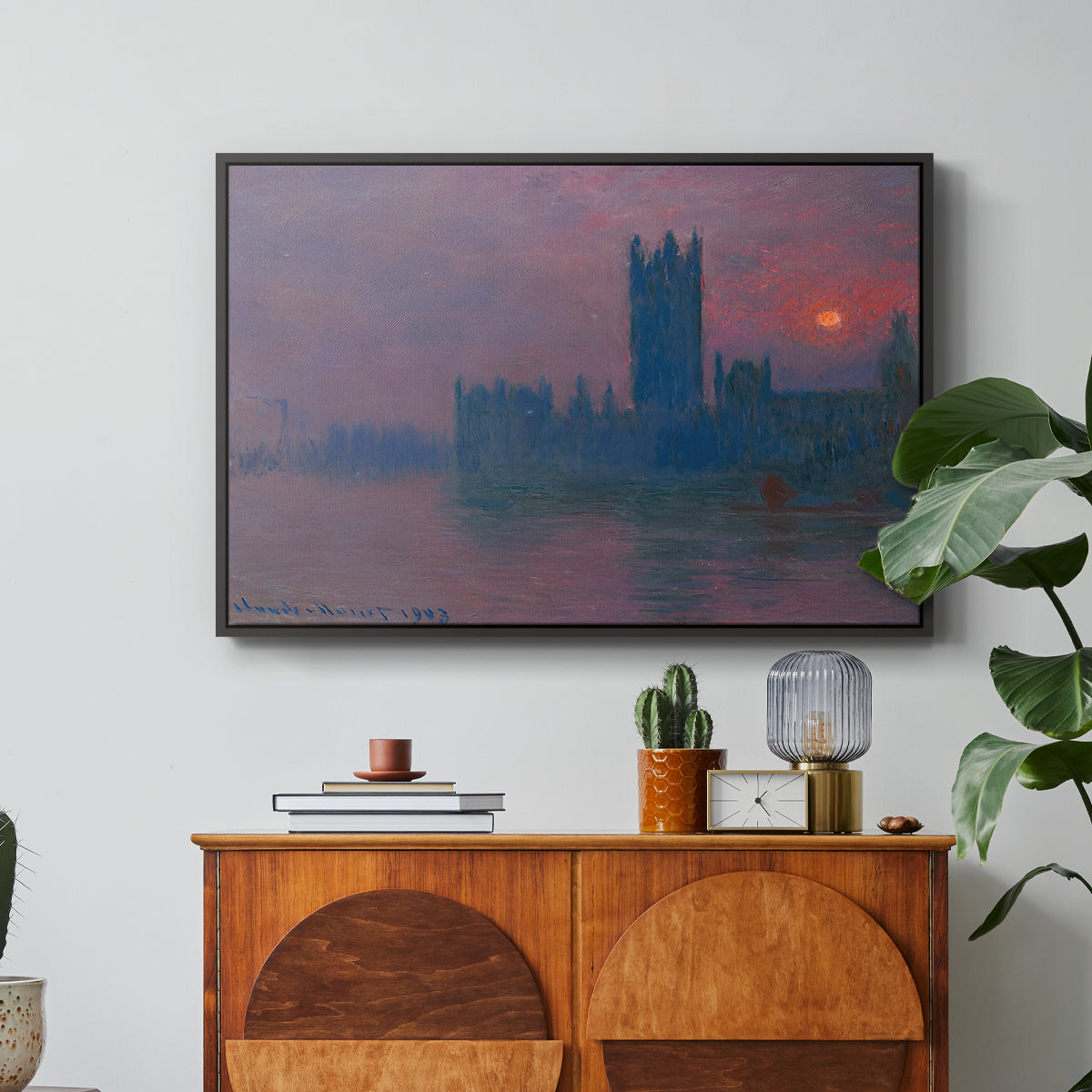 The Houses of Parliament, Sunset, 1903 by Claude Monet in a black floater framed canvas featuring a silhouette of Parliament buildings against glowing sunset across river, displayed above a wood console cabinet.