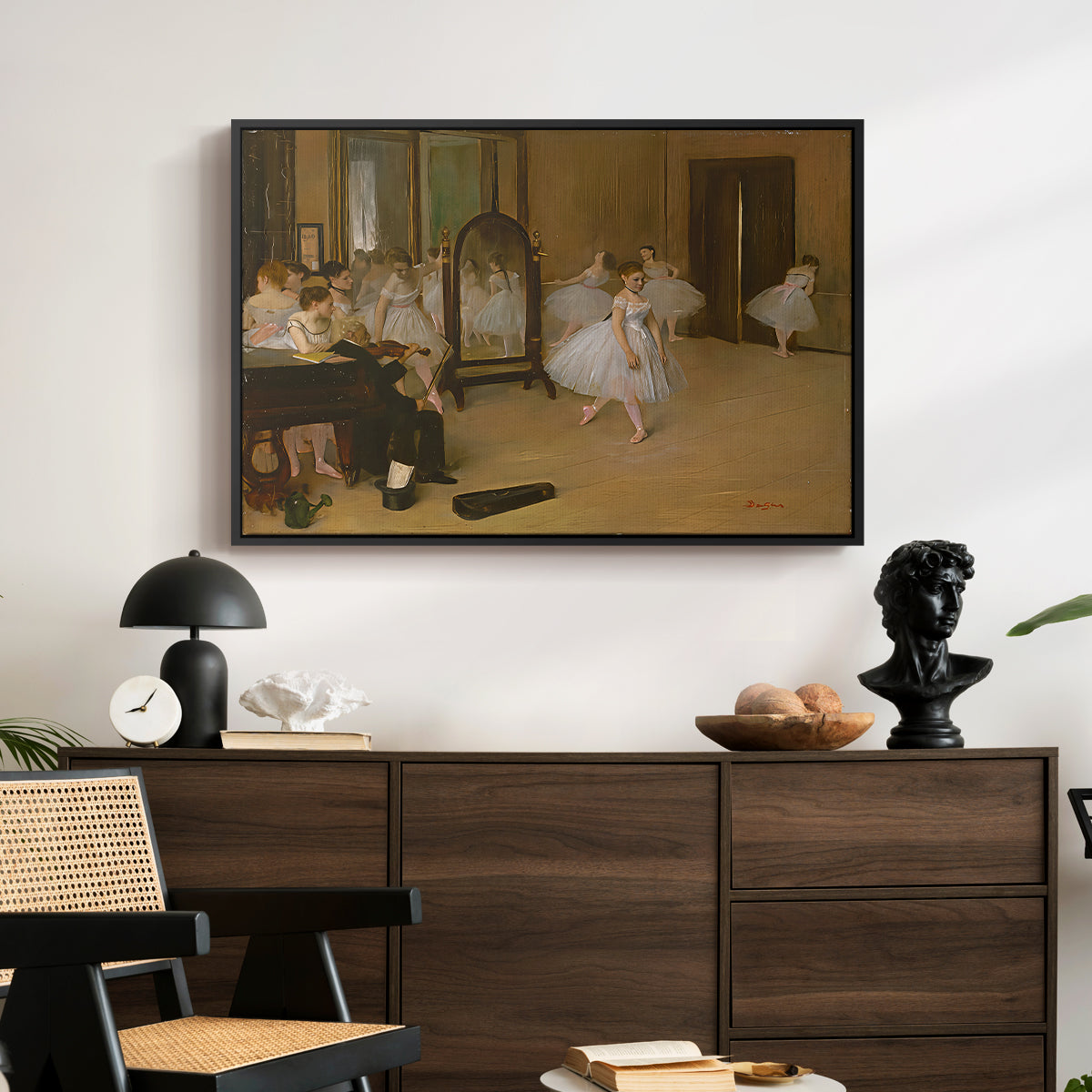 The Dancing Class, c. 1870 by Edgar Degas displayed in a black floater framed canvas above a dark wood credenza in an entryway.